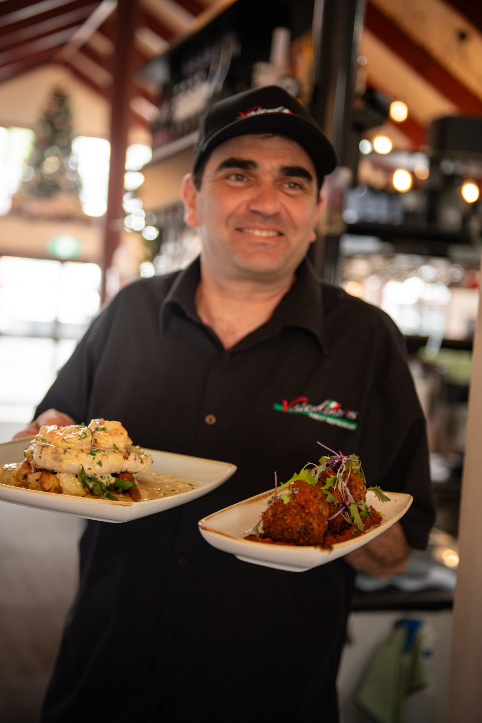 A person holding two plates of food.